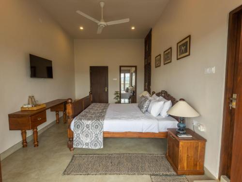 a bedroom with a bed and a table with a lamp at Edgar Mansion Kandy in Kandy