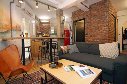 a living room with a couch and a brick wall at The 4 Travellers Thessaloniki in Thessaloniki