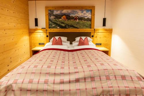 a bedroom with a large bed with red pillows at Madlhof in Himmelreich
