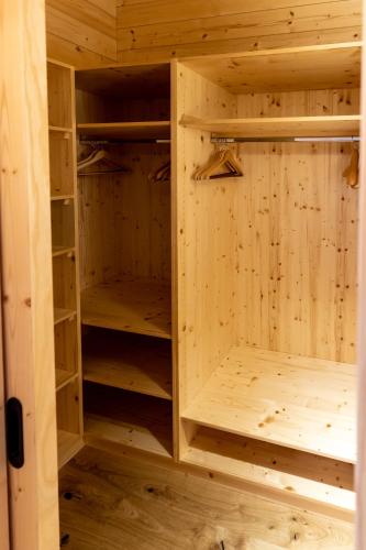 a closet in a log cabin with wooden shelves at Madlhof in Himmelreich