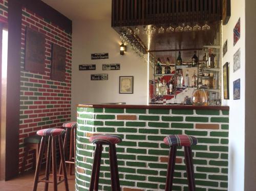a bar with stools in a room with a brick wall at Maison Clapp in Penedo