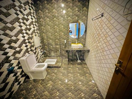 木爾坦的住宿－The Signature Hotel Multan，一间带卫生间、水槽和镜子的浴室