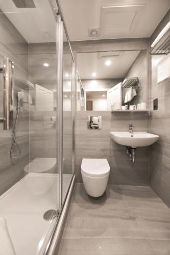 a bathroom with a shower toilet and a sink at Park Avenue Bayswater Inn Hyde Park in London