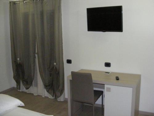 a room with a desk and a television on the wall at B&B Nuova Ostiglia in Quinto di Treviso