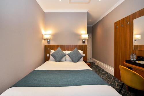 a hotel room with a bed and a desk at Park Avenue Bayswater Inn Hyde Park in London