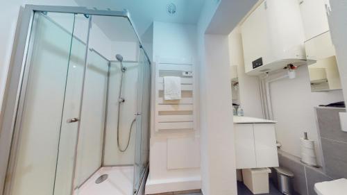 ein Bad mit einer Dusche und einer Glastür in der Unterkunft Le Beau Bourg *** in Straßburg