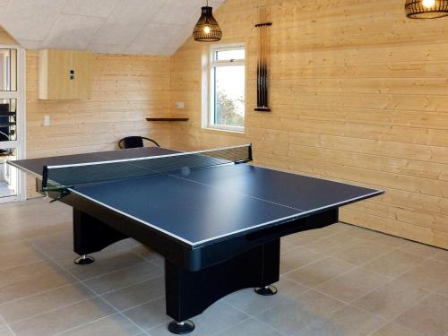 - une table de ping-pong dans une pièce dotée de murs en bois dans l'établissement 8 person holiday home in Ebeltoft, à Ebeltoft