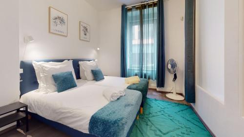 ein Schlafzimmer mit einem großen Bett und einem blauen Sofa in der Unterkunft Le Beau Bourg *** in Straßburg