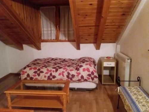 een kleine slaapkamer met een bed en een tafel bij Adosado gran terraza parking bodega ideal bicis in Villanova