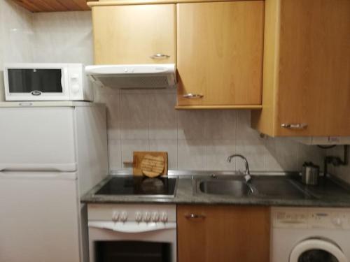una piccola cucina con lavello e microonde di Adosado con gran terraza a Villanova