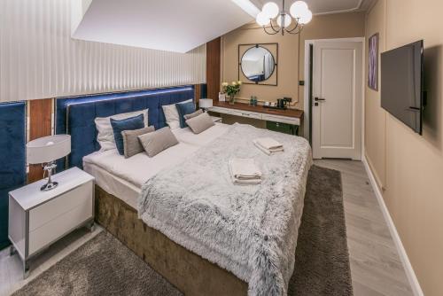 a bedroom with a large bed with a blue headboard at Austeria Kazimierska in Kazimierz Dolny