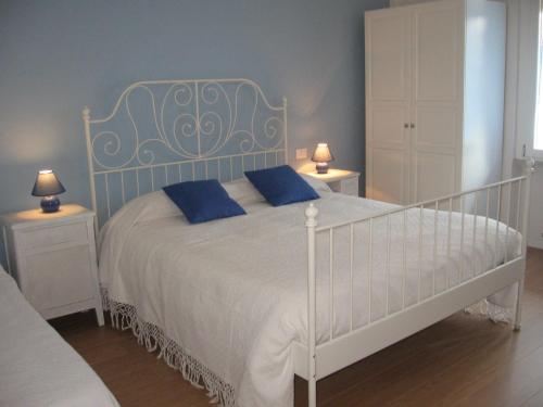 una camera da letto con un letto bianco con cuscini blu di B&B Il Paiolo a Desenzano del Garda