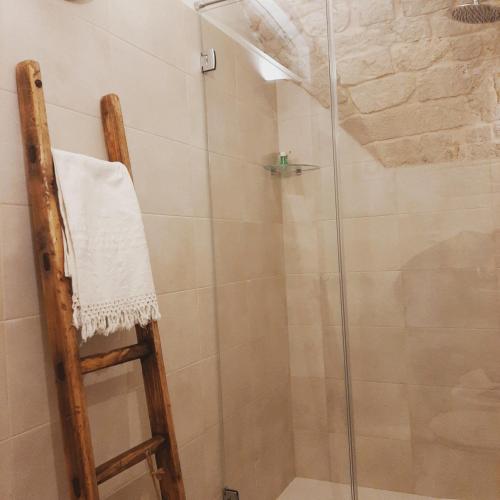 a shower with a glass door with a towel on a ladder at Lumè in Putignano