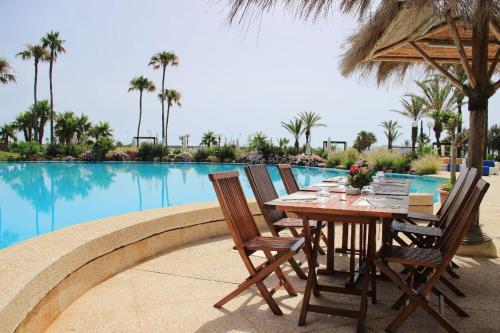 a table and chairs next to a swimming pool at Marina Smir Hotel & Spa in M'diq