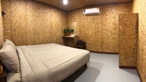 a bedroom with a bed and a wall at Navareeya House Seaview in Ko Lanta