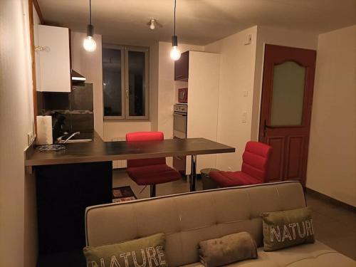 Il comprend un salon avec un canapé et une cuisine avec des chaises rouges. dans l'établissement la maison du bonheur, à Saint-Germain-Laval