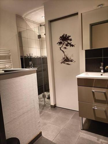 La salle de bains est pourvue d'une douche, d'un lavabo et d'une porte de douche. dans l'établissement la maison du bonheur, à Saint-Germain-Laval