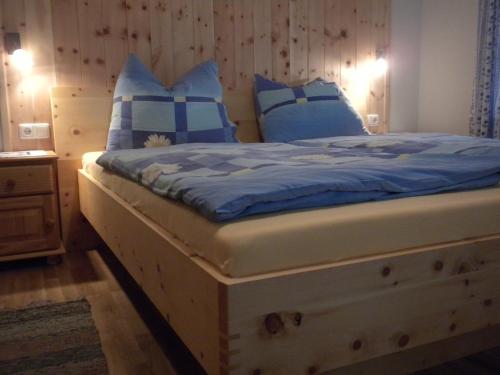 a bedroom with a bed with blue and white pillows at Bio-Urlaubshof Dansbach in Spital am Pyhrn