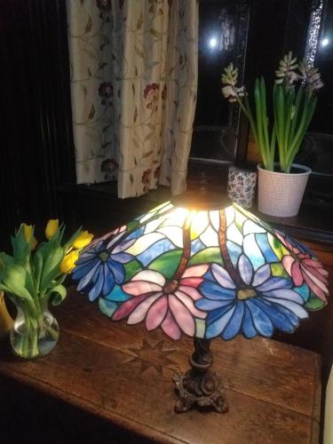 a stained glass umbrella on a table with flowers at JESMOND House B&B room 1 in Hull