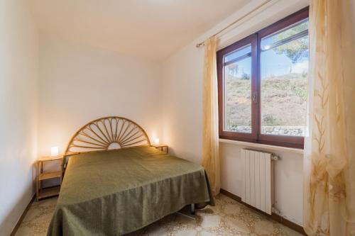 una camera da letto con un letto e una finestra di Villa Campo al Pero a Rio Marina