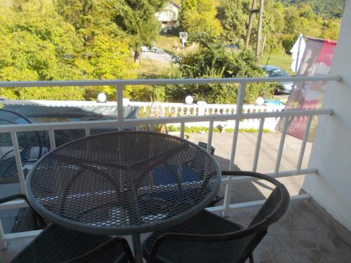 a table and chairs sitting on a balcony at Panorama Apartman in Molvice
