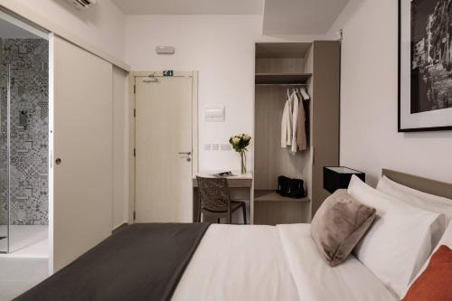 een slaapkamer met een bed en een bureau in een kamer bij Urban Isle Hotel in Il-Gżira