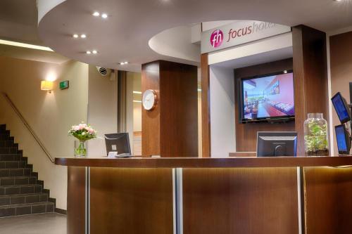 a hotel lobby with a reception desk and a tv at Focus Hotel Szczecin in Szczecin
