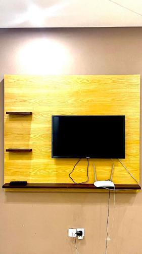 telewizor z płaskim ekranem na drewnianej ścianie w obiekcie Tanagra Mall appartement de Luxe a côté de la Gare TGV w mieście Kenitra