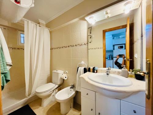 La salle de bains est pourvue d'un lavabo, de toilettes et d'un miroir. dans l'établissement Apartamento Mar y Montaña, à Cullera