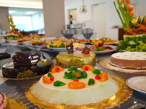 Cefalu Resort - Sporting Club في تشفالو: طاولة مليئة بالكعك وأطباق الطعام