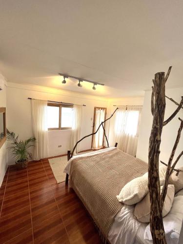 a bedroom with a bed and a tree at VILLA NEYRA 