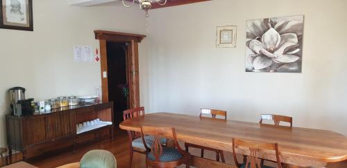 a dining room with a wooden table and chairs at The Sleeping Bao B&B in Pietermaritzburg