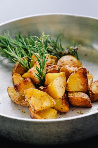 a plate of potatoes with rosemary on top at AGRITURISMO CA' FENILE in Alzano Lombardo