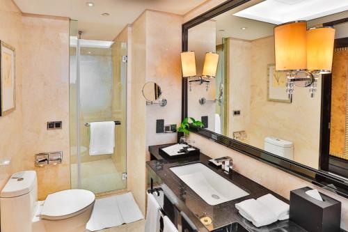 ein Bad mit einem WC, einem Waschbecken und einer Dusche in der Unterkunft Changzhou Yuanzhou Hotel in Changzhou