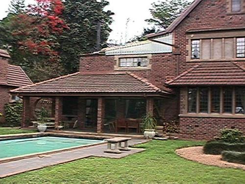 a house with a swimming pool in the yard at The Sleeping Bao B&B in Pietermaritzburg