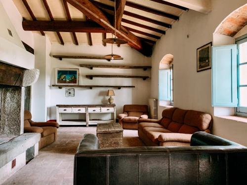 Casale gli ulivi في Donnini: غرفة معيشة مع أريكة ومدفأة
