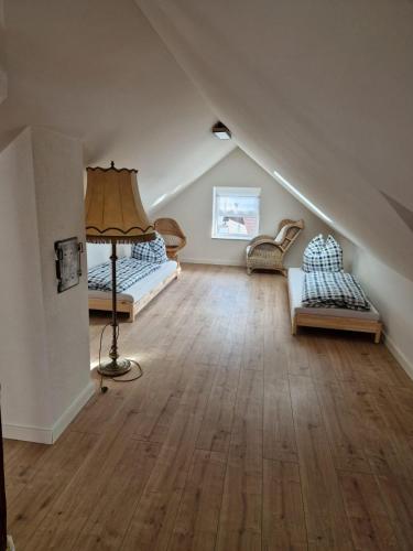a attic room with two beds and a lamp at Ferienwohnung Amo in Wangen im Allgäu
