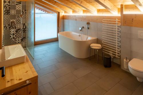 a bathroom with a tub and a sink and a toilet at Madlhof in Himmelreich