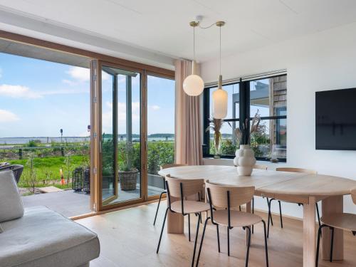 a dining room with a table and chairs and a large window at Luksus ferielejlighed med 3 soverum ved stranden i Kerteminde in Kerteminde