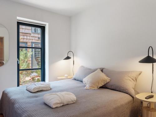 um quarto branco com uma cama com duas almofadas em Luksus ferielejlighed med 3 soverum ved stranden i Kerteminde em Kerteminde
