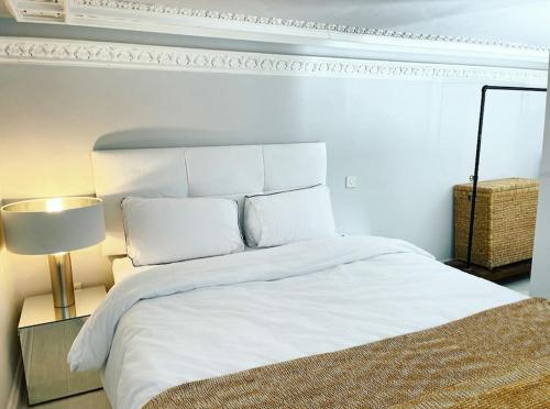 una camera con letto bianco e lampada di 22 Stunning Large Loft - Great Location - Free Onsite Parking - Garden View- Quiet a Brighton & Hove