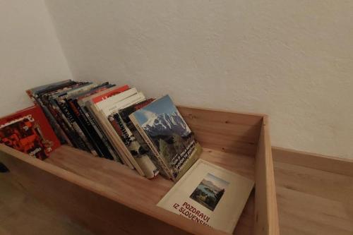 a book shelf with a pile of books at Miklavževa hiša with a bread oven in Železniki