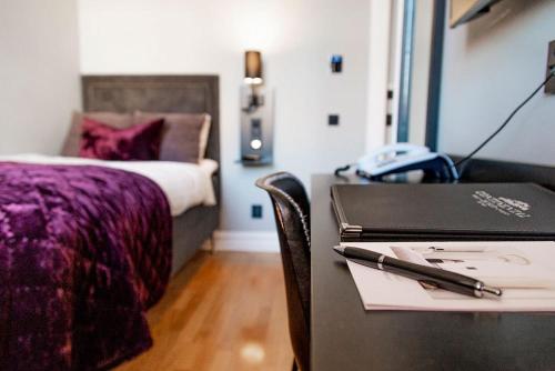 a bedroom with a desk with a laptop and a bed at Continental du Sud in Ystad
