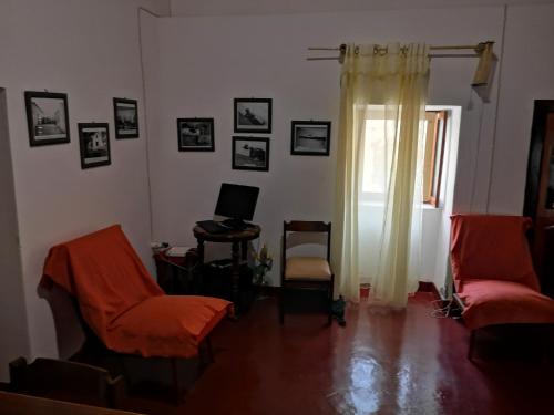 sala de estar con 2 sillas y ordenador en la pared en Kaza Ladera en Seladinha