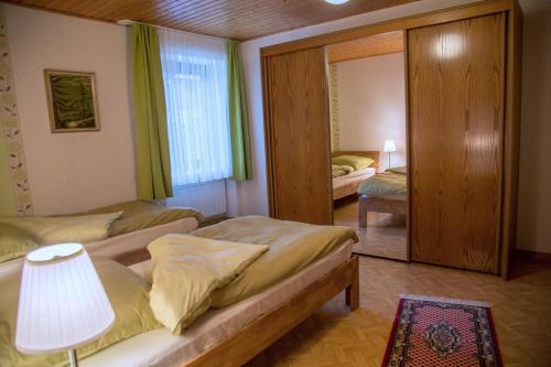 1 dormitorio con 2 camas individuales y espejo en Ferienhaus Fisch, 