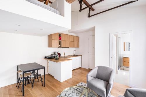 a kitchen and living room with a table and chairs at Tourville - Très beau studio - Bail mobilité in Paris