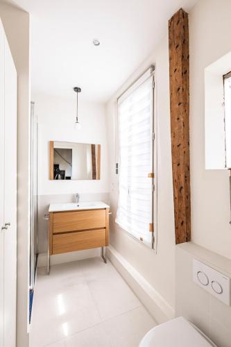 une salle de bain avec un lavabo et une fenêtre dans l'établissement Tourville - Très beau studio - Bail mobilité, à Paris