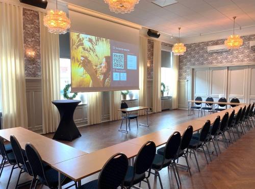 a conference room with tables and chairs and a screen at Continental du Sud in Ystad