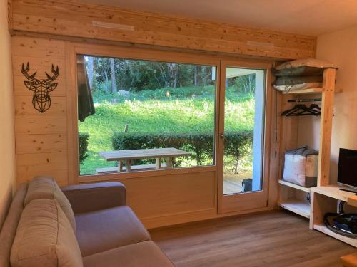 a living room with a large sliding glass door at Le cocon du Bettex 1400 - Cozy Apt near Mont Blanc in Saint-Gervais-les-Bains