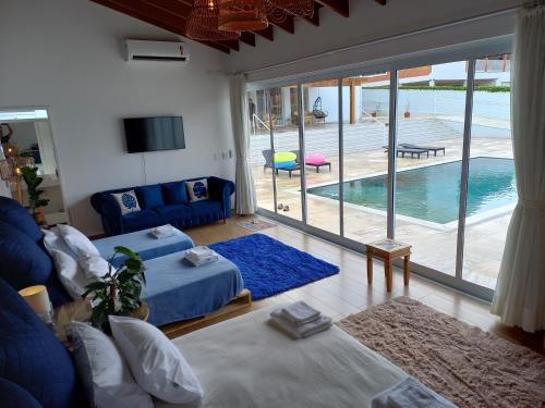 a living room with a blue couch and a swimming pool at Casa francesa de Piraju in Piraju